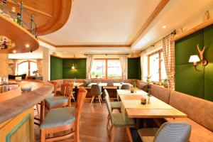 a restaurant with green walls and tables and chairs at Hotel Jagdhof in Riezlern