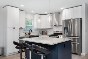 a kitchen with white cabinets and a large island with black bar stools at Catchy Relax Bradenton Beauty mins to Beaches in Bradenton