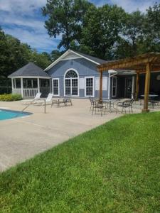 a pavilion with tables and chairs in front of a house at A Touch of Sunshine Ideal For Long Term Stays in Fayetteville