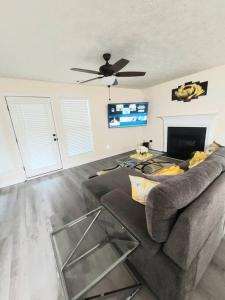 a living room with a couch and a ceiling fan at A Touch of Sunshine Ideal For Long Term Stays in Fayetteville