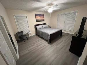 a bedroom with a bed and a television in it at A Touch of Sunshine Ideal For Long Term Stays in Fayetteville