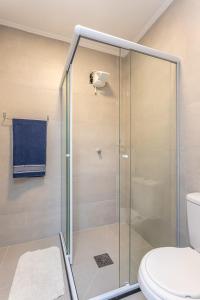 a bathroom with a glass shower with a toilet at Aconchegante e ensolarado! in Porto Alegre