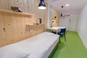 a room with a bed and a desk and a table at Koala Hostel Mercado in Alicante