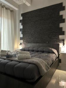 a large bed in a room with a brick wall at B&B Il Sogno in Lamezia Terme