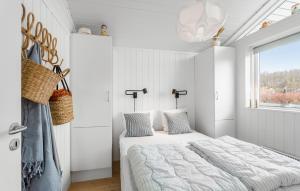 a white bedroom with a bed and a window at 2 Bedroom Lovely Home In Rudkøbing in Spodsbjerg
