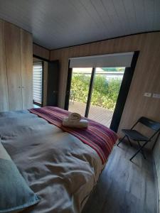 a bedroom with a large bed with a large window at Puerta Punta de Lobos in Pichilemu