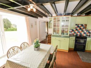 uma cozinha com armários verdes e uma mesa com uma toalha de mesa em Woodlands Cottage em Scarborough