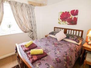 um quarto com uma cama com cobertores e almofadas em Woodlands Cottage em Scarborough