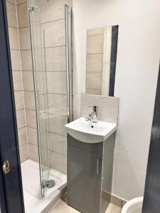 a bathroom with a sink and a shower at Everlight Basildon House in Basildon