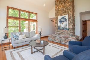 a living room with a couch and a stone fireplace at River Haven with Hot Tub in Delta