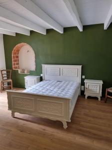 - une chambre avec un lit blanc dans un mur vert dans l'établissement Gîte au cœur des vignes, à Cazes-Mondenard