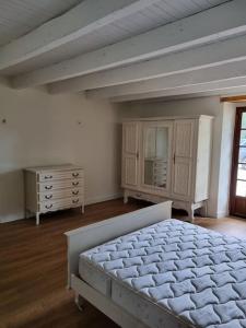 - une chambre avec un lit blanc et une commode dans l'établissement Gîte au cœur des vignes, à Cazes-Mondenard