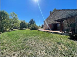 une maison avec une cour herbeuse à côté d'un bâtiment dans l'établissement Gîte au cœur des vignes, à Cazes-Mondenard