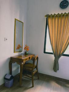 a desk and a chair in a room with a window at Homestay Sente in Munduk