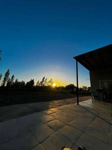 a sun setting in the sky behind a pavilion at quincho el atardecer in Santa Lucía