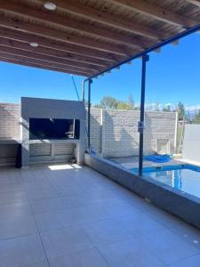 eine Terrasse mit einem Pool und einem Kamin in der Unterkunft quincho el atardecer in Santa Lucía