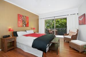 a bedroom with a large bed and a balcony at Byron Bay Accom - Alkira 1/32 Alcorn St in Suffolk Park