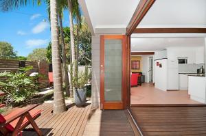 a house with a wooden deck with a kitchen at Byron Bay Accom - Alkira 1/32 Alcorn St in Suffolk Park