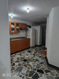 eine Küche mit Steinboden und weißen Geräten in der Unterkunft Alojamiento cómodo en el centro de la ciudad. in Pereira