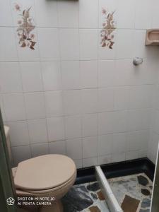 ein Bad mit einem WC und einer gefliesten Wand in der Unterkunft Alojamiento cómodo en el centro de la ciudad. in Pereira