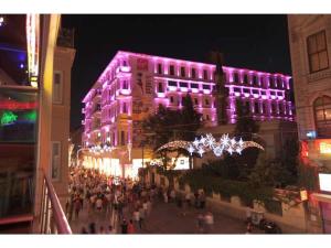 a group of people walking in front of a building with purple lights at Venus Hotel Taksim in Istanbul