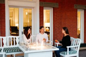 Un groupe de trois personnes assises autour d'une table dans l'établissement The Omni Homestead Resort, à Hot Springs