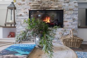 a living room with a fireplace and a table with a plant at Cottage Enchantment Blooming Garden Getaway in Red Hill South