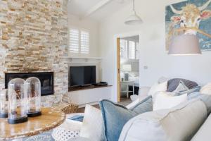 a living room with a couch and a fireplace at Cottage Enchantment Blooming Garden Getaway in Red Hill South