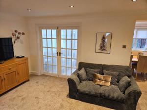 a living room with a couch and a television at 3 Severn close Contractor home in Oakham in Oakham