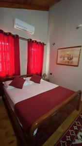 a bedroom with a large bed with red curtains at ROOMS EMILIANO Castle of Kruja in Krujë