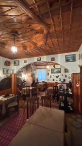un restaurante con techos de madera, mesas y sillas en ROOMS EMILIANO Castle of Kruja, en Krujë