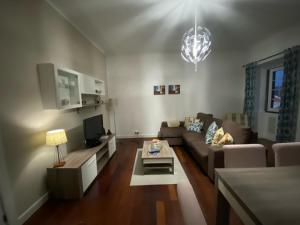 a living room with a couch and a table at Alojamento Quadros in Horta