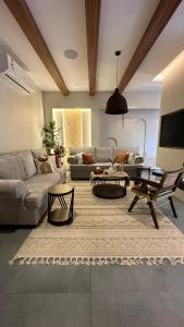 شاليه أوڤال Oval Chalet في Al Jubail: غرفة معيشة مع أريكة وطاولة