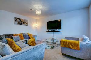 sala de estar con 2 sofás y TV de pantalla plana en St Andrews Park - Coorie Doon Stays, en Troon