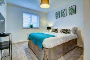 sypialnia z łóżkiem z niebieskim kocem w obiekcie St Andrews Park - Coorie Doon Stays w mieście Troon