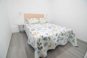 a bedroom with a bed with a floral comforter at The Safe Point Suites Tablero in El Tablero
