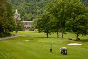 a man is playing golf on a green at The Omni Homestead Resort in Hot Springs