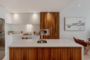 una cucina con lavandino e piano di lavoro di Center 1-Bed with Gym, BBQ and Stunning Views a Canberra