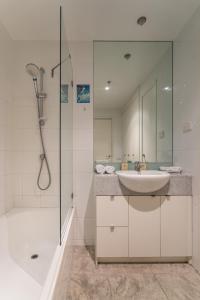 a white bathroom with a sink and a shower at IMSA Group in Melbourne