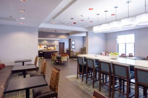 a restaurant with tables and chairs and a bar at Hampton Inn Haverhill in Haverhill