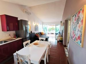 a kitchen and living room with a white table and chairs at Los Porches D40 By Pride Holiday Rentals in San Bartolomé