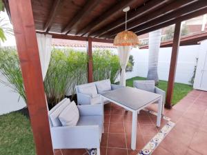 d'une terrasse avec une table et des chaises blanches. dans l'établissement Los Porches D40 By Pride Holiday Rentals, à San Bartolomé