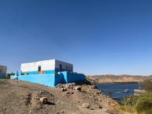 Humble Nubia في أسوان: مبنى بلو وبيض على جانب تل