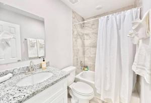 a white bathroom with a sink and a toilet at Luxury 3BR Home Downtown Houston and near Airport in Houston