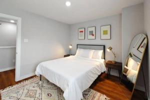 a bedroom with a large white bed and a mirror at Luxury 3BR Home Downtown Houston and near Airport in Houston
