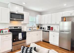 a kitchen with white cabinets and stainless steel appliances at Luxury 3BR Home Downtown Houston and near Airport in Houston