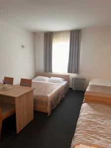 ein Hotelzimmer mit 2 Betten und einem Tisch in der Unterkunft Apartman Masa Kopaonik in Kopaonik