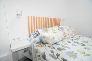 Una cama con una almohada con flores. en The Safe Point Suites Tablero, en El Tablero