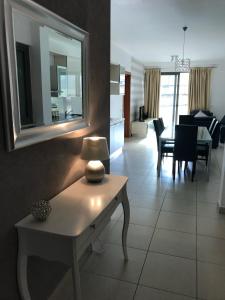 a living room with a table with a mirror on the wall at Spinola Residence St Julians in St Julian's