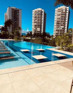 a large swimming pool with two tall buildings at Cômodo perfeito in Rio de Janeiro